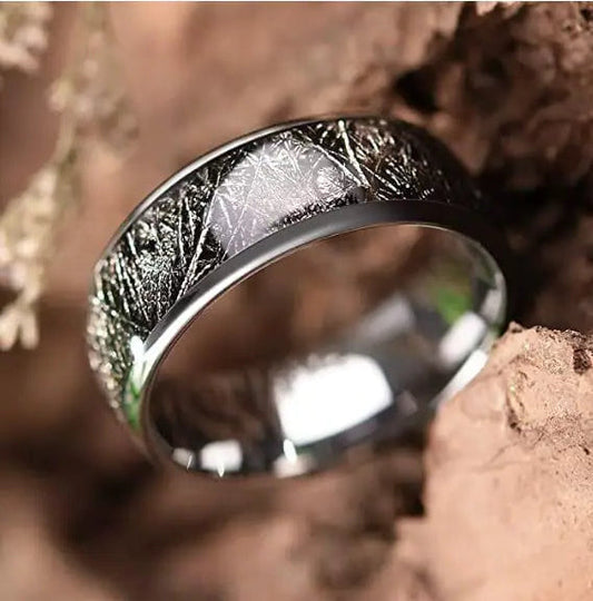 Silver ring with textured design on a natural background