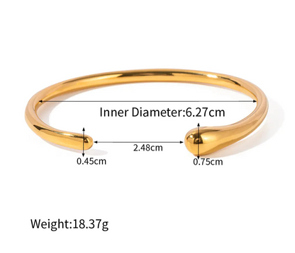 Gold bracelet with measurements on a white background